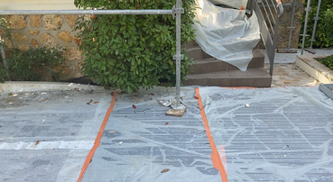 Trianon Façades : balcon en pierre avec chaise et petit objet sur le sol